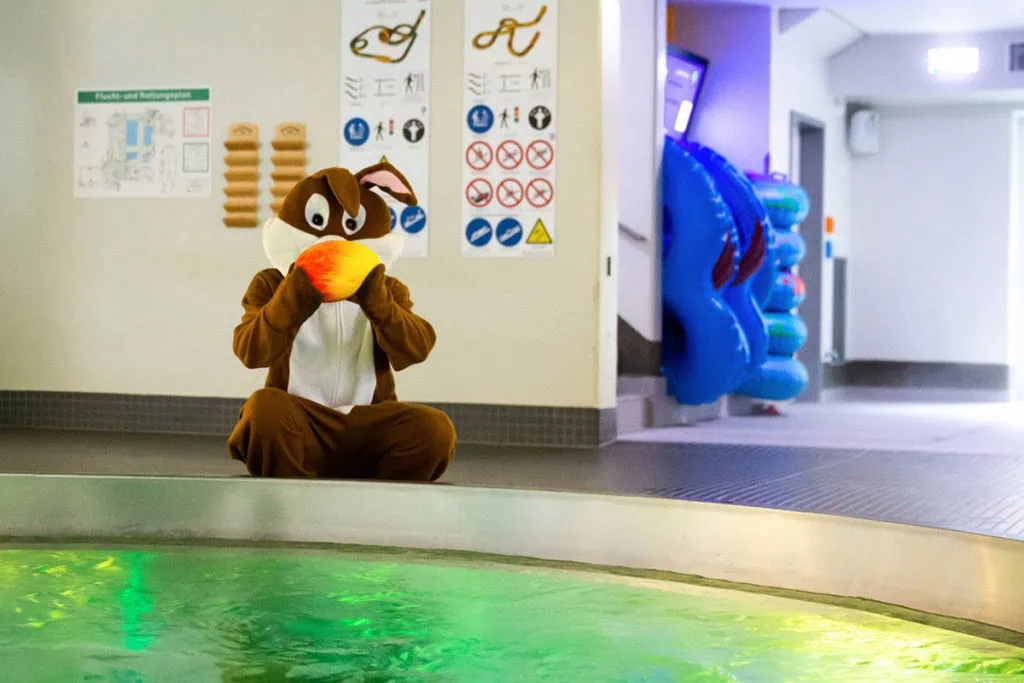 Osterhase färbt Eier im Schwimmbecken vom Hains