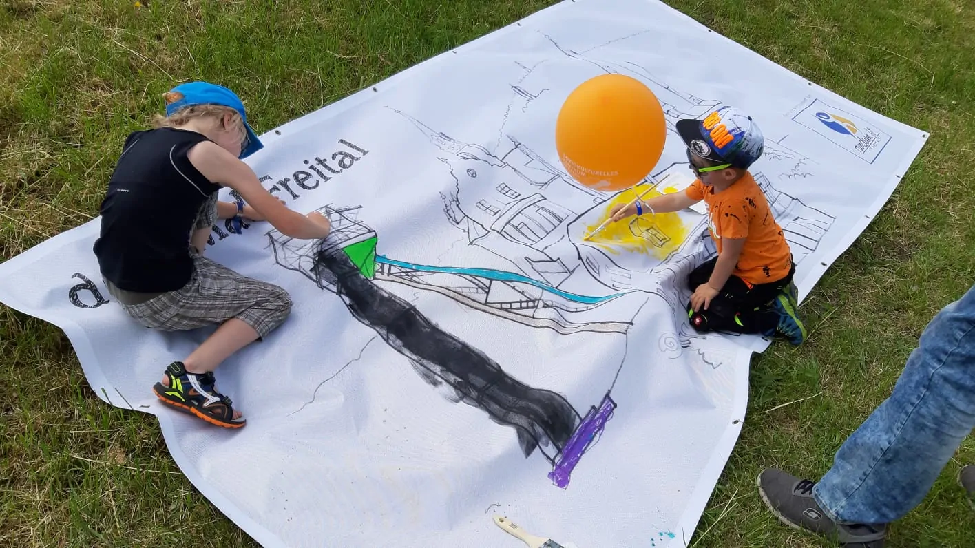 Kinder malen die Plane von RundumFit Freital aus